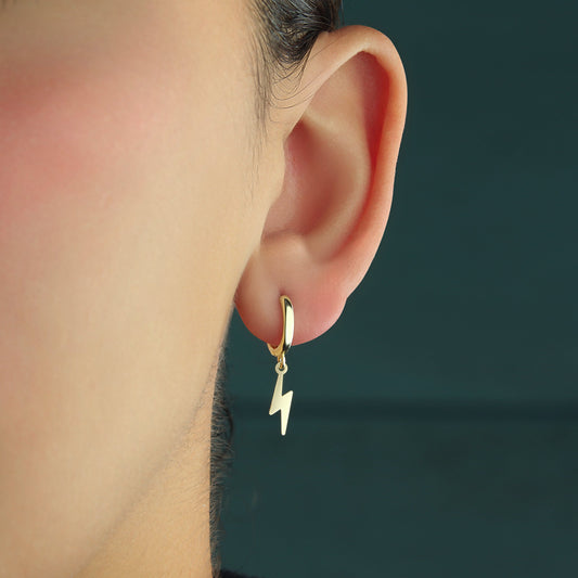 GIOVE MIO Exclusive Lightning Pendant Huggies in 14kt Yellow Gold. Gold earrings with a radiant lightning charm. Elevate your style with these unique Huggies. Illuminate your look today!
